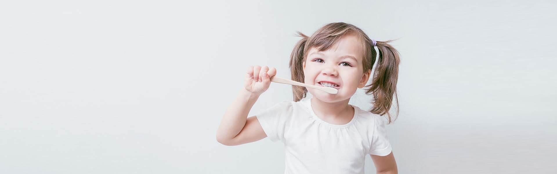 Child girl brushes her teeth with a bamboo toothbrush. concept: environmental care, zero waste, ecology