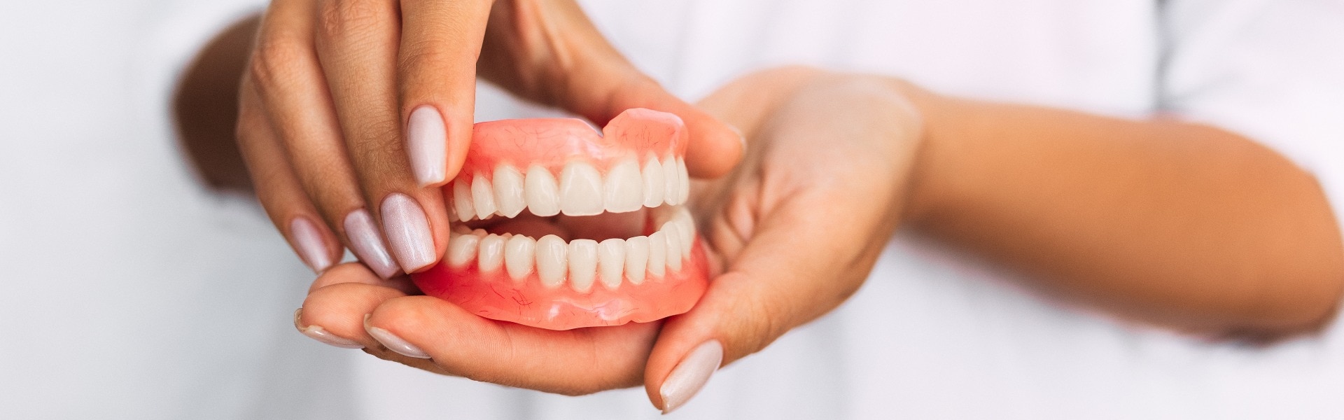 The dentist is holding dentures in his hands dental prosthesis in the hands of the doctor close up front view of complete denture dentistry conceptual photo prosthetic dentistry false teeth jpg