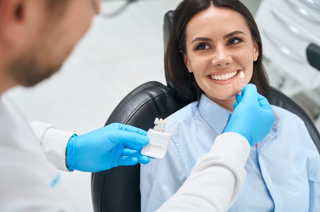 Hochqualifizierter Zahntechniker bei der Auswahl der richtigen Größe und Farbe der Zahnkrone
